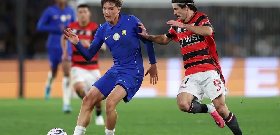Player in blue jersey dribbling past opponent in red
