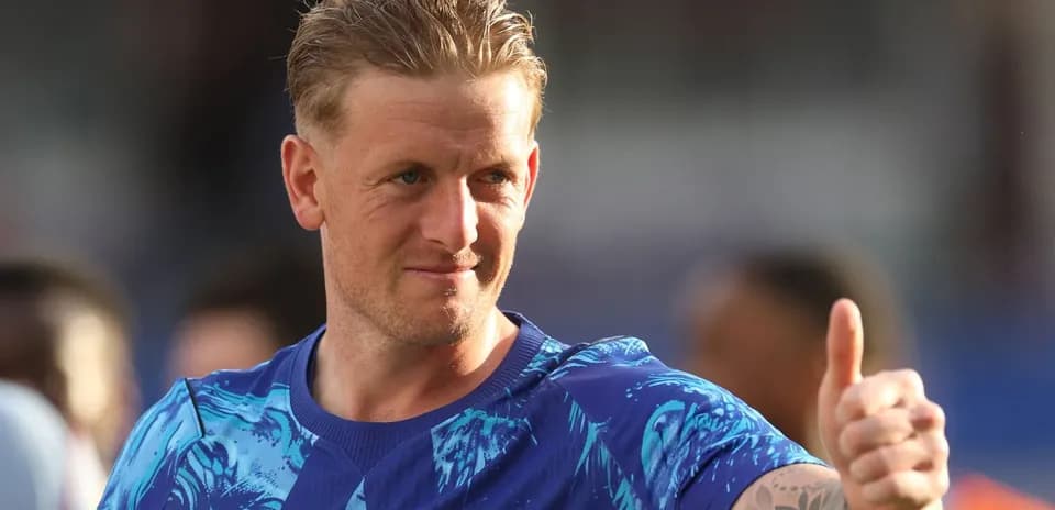 Futbolchi maydonda qo'lini ko'tarib turgan