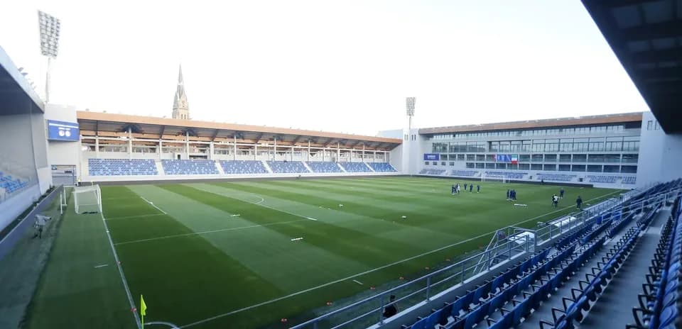 Stadium field with players training before match