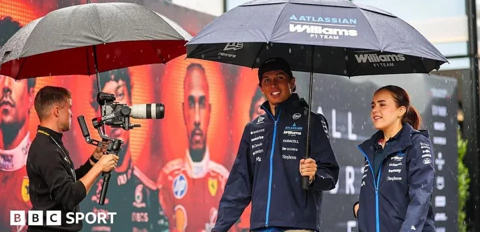 Williams F1 Team members under umbrellas during event