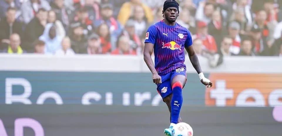 Futbolchi to'pni nazorat qilmoqda, stadionda tomoshabinlar