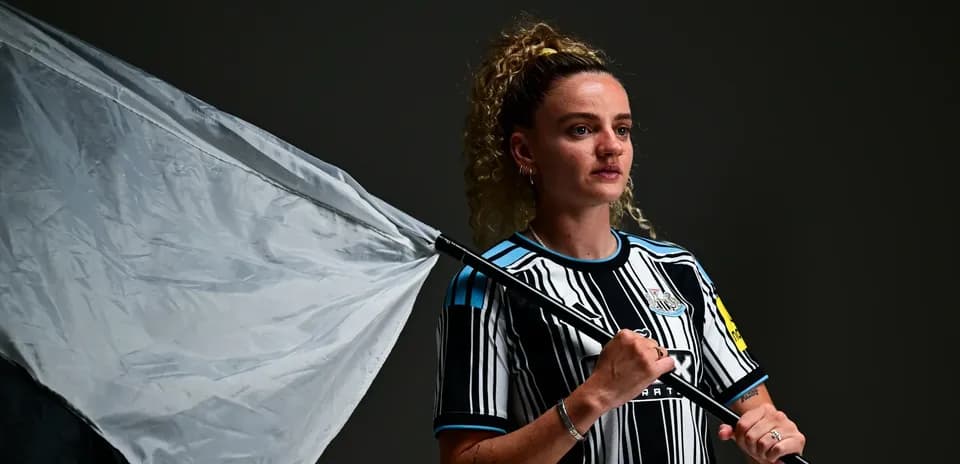 Futbolchi bayroq bilan poz berayotgan surat