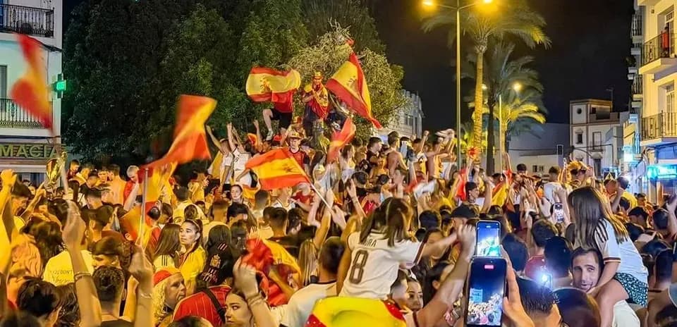 Jubilation of fans celebrating with flags at night