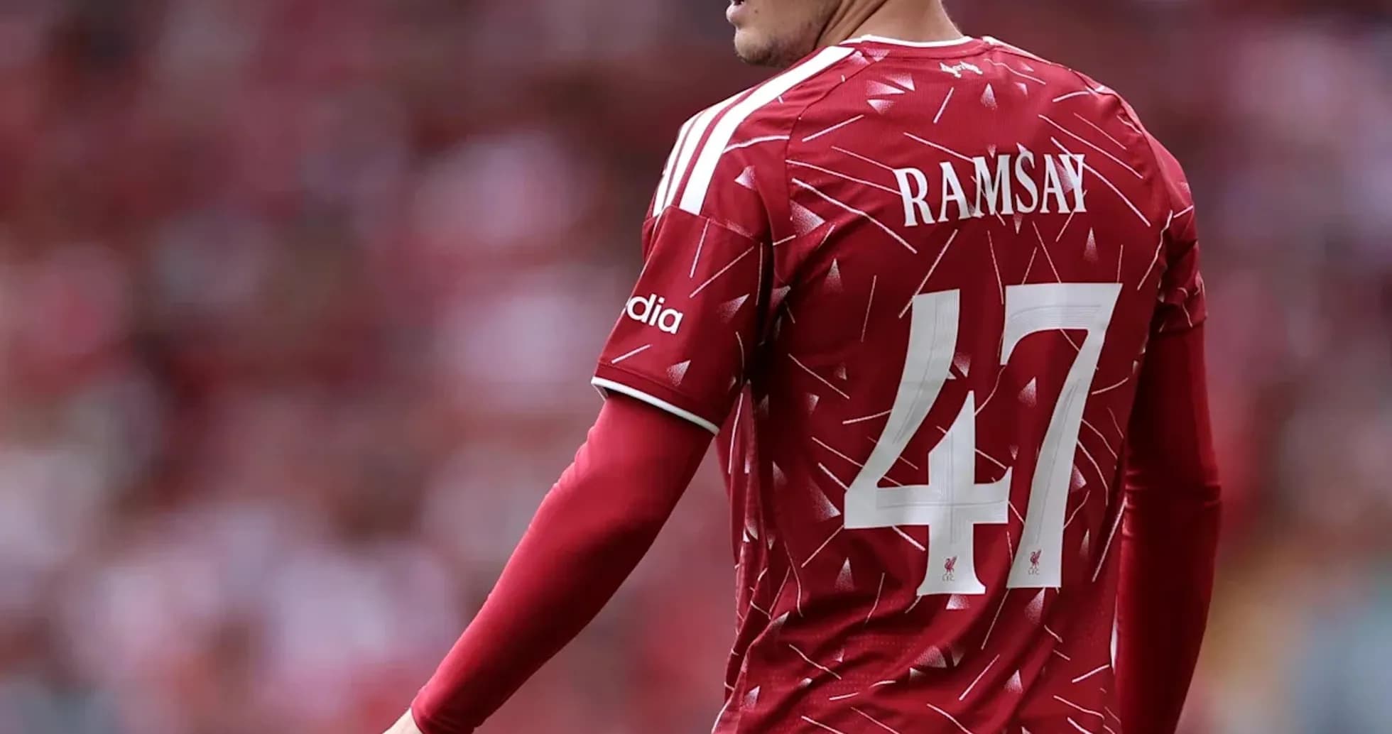 Futbolchi Ramsay qizil futbolka kiyib turibdi
