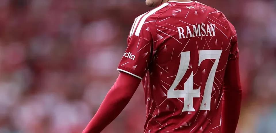Futbolchi Ramsay qizil futbolka kiyib turibdi