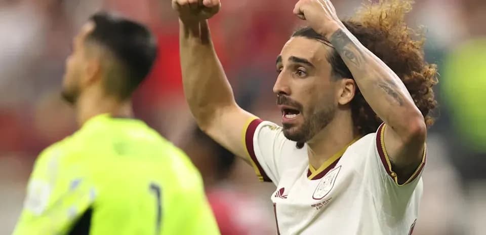 Futbolchi jamoasi o'yin davomida qo'lni ko'tarib turibdi
