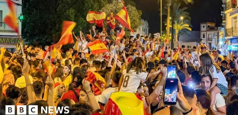 Odamlar Ispaniya bayroqlarini tutib, shodlik qilmoqda