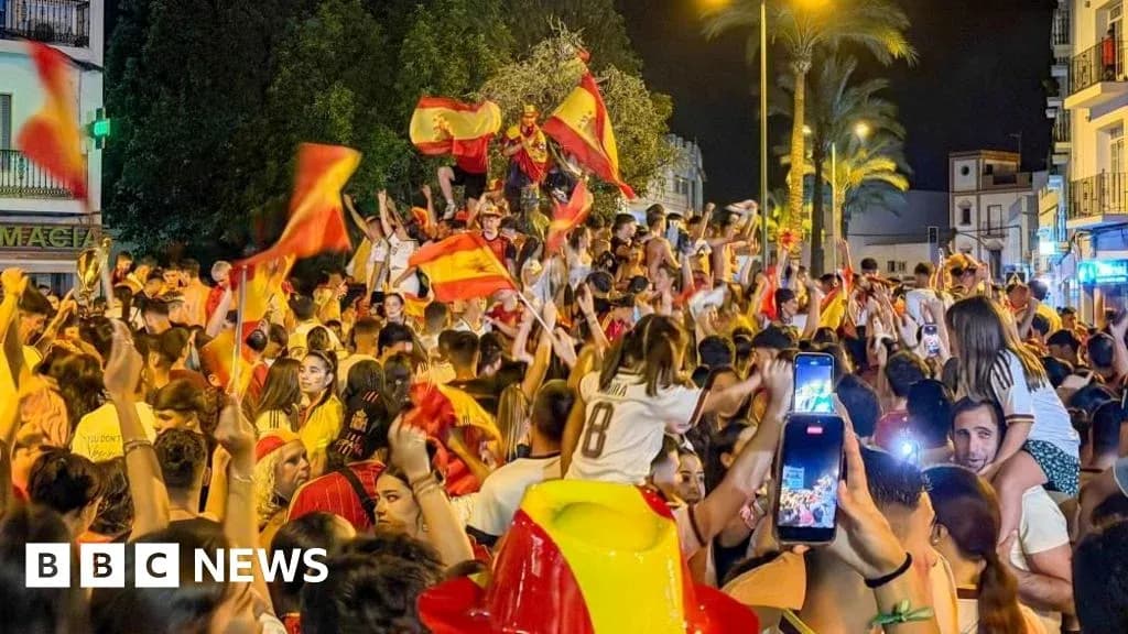 Odamlar Ispaniya bayroqlarini tutib, shodlik qilmoqda