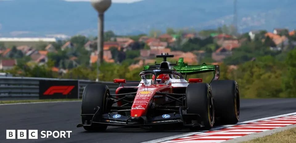 Formula 1 car racing on track with hills in background