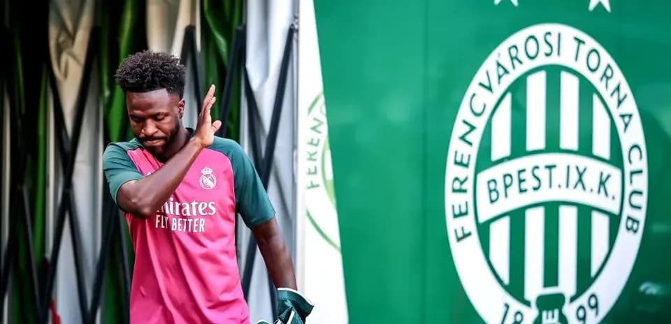 Futbolchi Ferentsvaroshi klubining logosi oldida