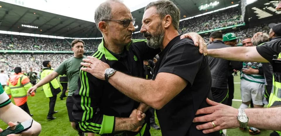 Two coaches embracing on the pitch after match