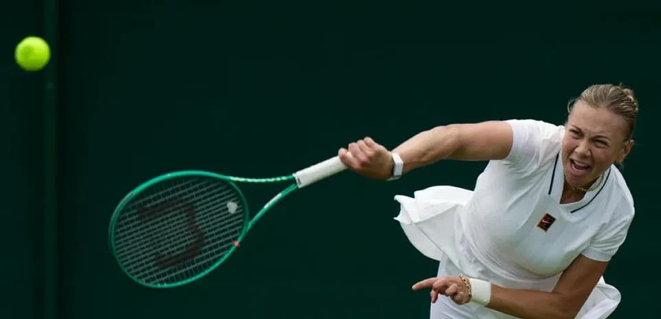 Tennis player serving during a match at Wimbledon