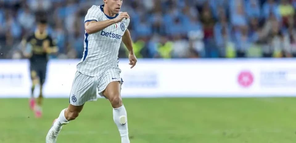 Futbolchi to'pni ushlab, maydon bo'ylab yugurmoqda