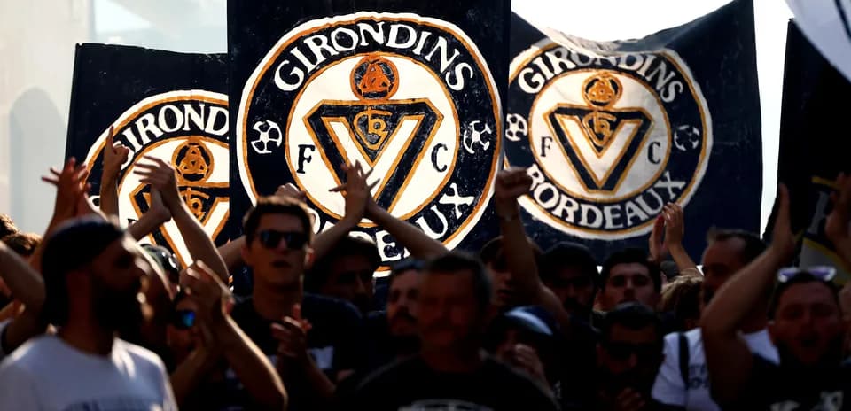 Girondins de Bordeaux fans holding banners and cheering