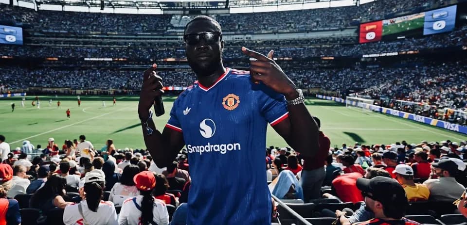 Fan in Manchester United jersey at crowded stadium