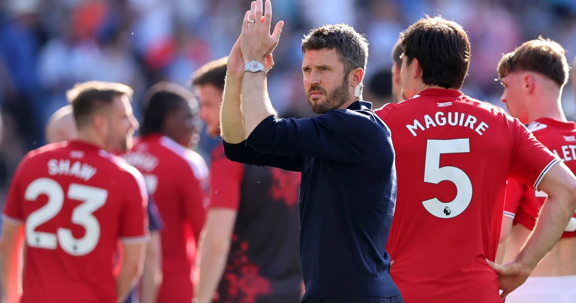 Men's football team applauding fans after match