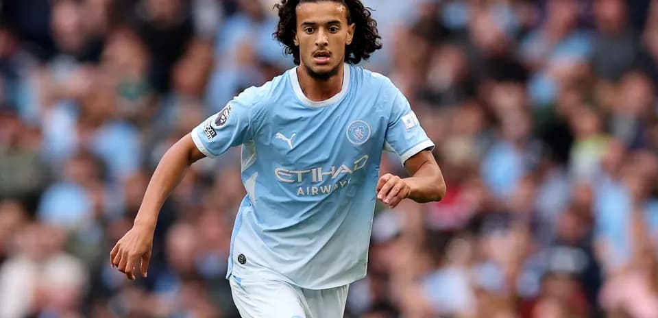 Futbolchi Manchester City formasida to'pni ushlab bormoqda