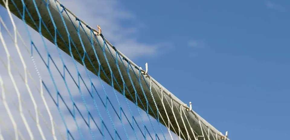 Football goal net against blue sky background