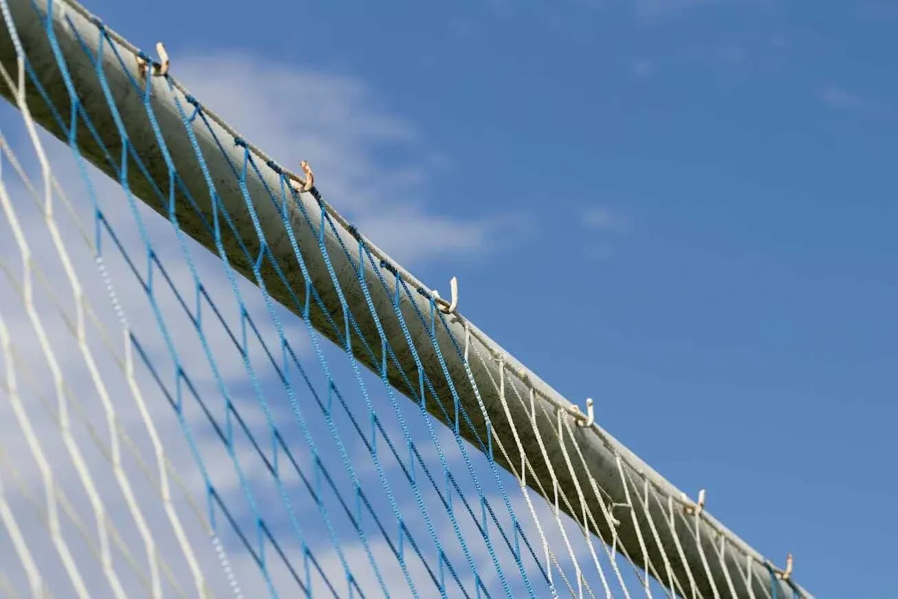 Football goal net against blue sky background