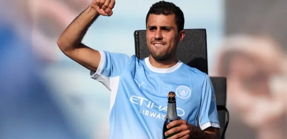 Futbolchi shampan bilan maydonda qo'lni ko'targan
