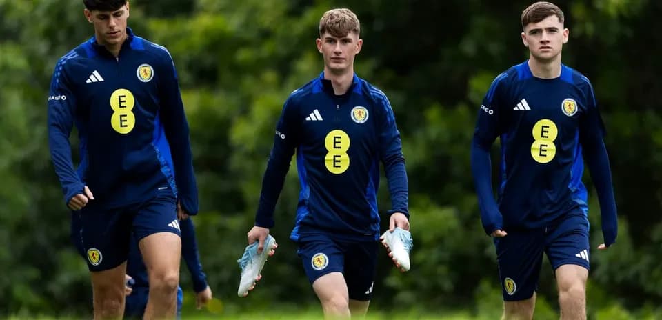 Three players walking in training kits with boots