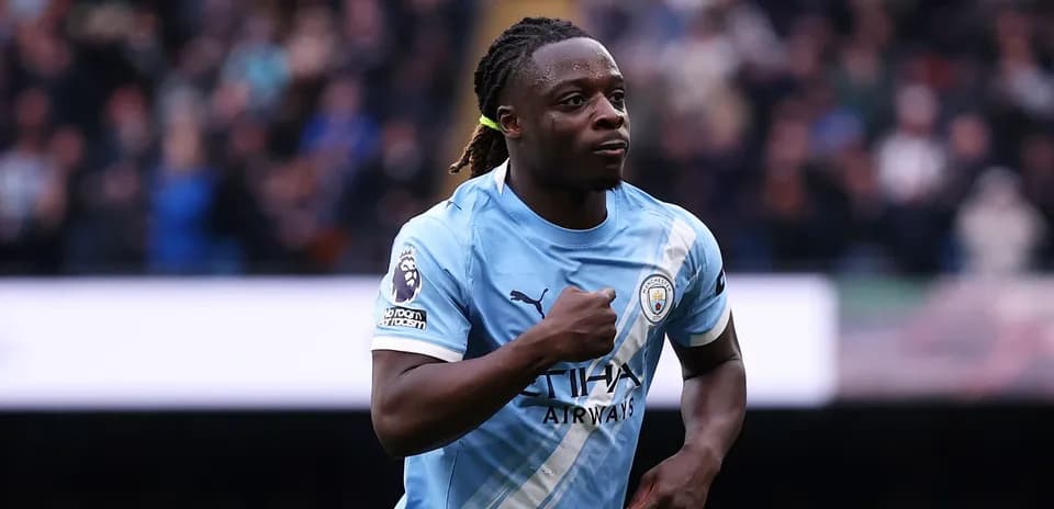 Futbolchi Manchester City formasida maydonda yugurmoqda