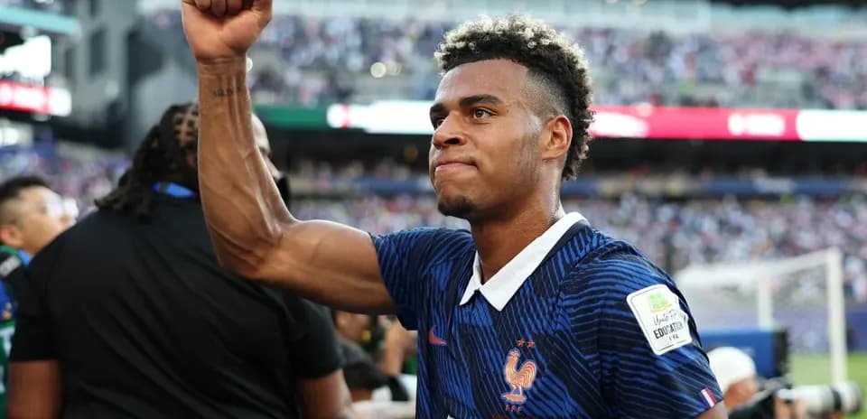 Futbolchi o'yinchisi g'alaba belgisini ko'rsatmoqda