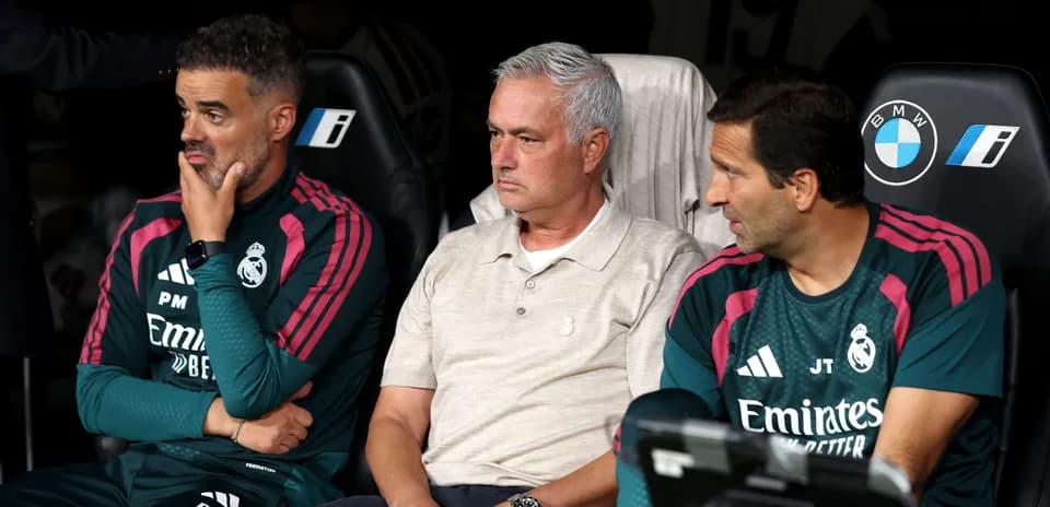 Coaches seated on bench during match