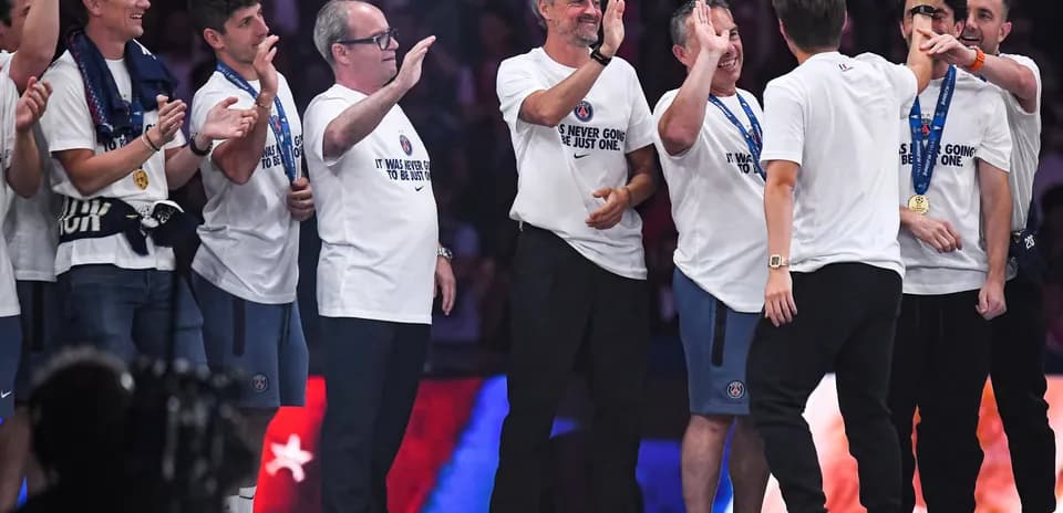Coaching staff celebrating with team medals on stage