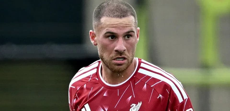 Futbolchi qizil formada maydon bo'ylab harakatda