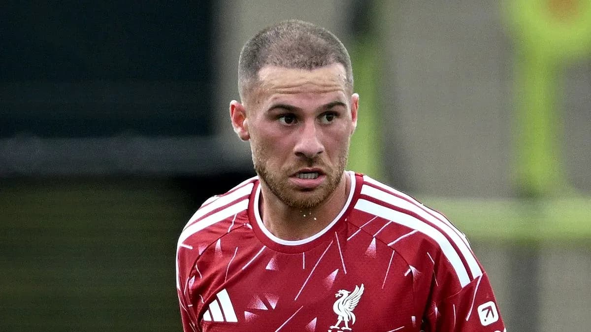 Futbolchi qizil formada maydon bo'ylab harakatda