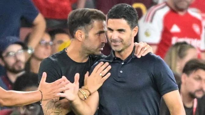 Two men conversing on the sidelines during match