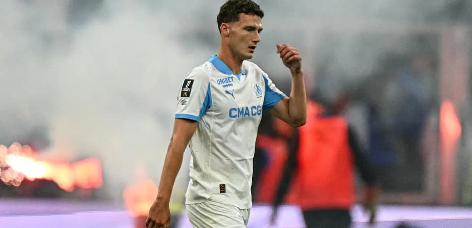 Futbolchi maydonda yurib ketmoqda, tutun fonida