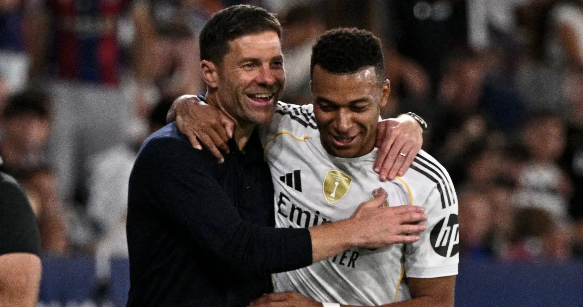 Trener va futbolchi quchoqlashmoqda, stadionda