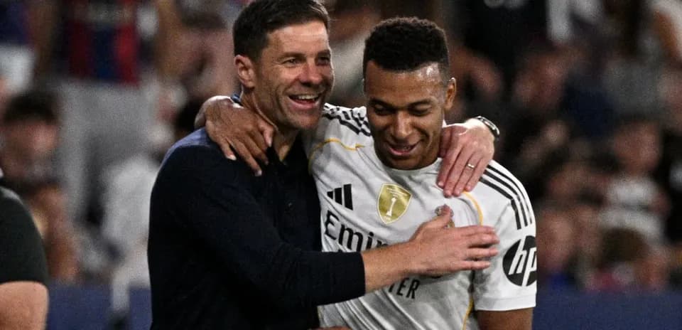 Trener va futbolchi quchoqlashmoqda, stadionda