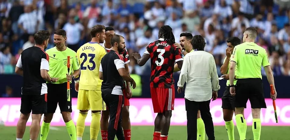 Players and officials discussing on the pitch