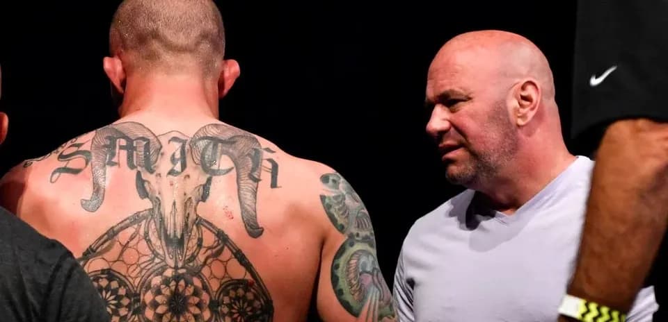 Tattooed fighter discussing with UFC president