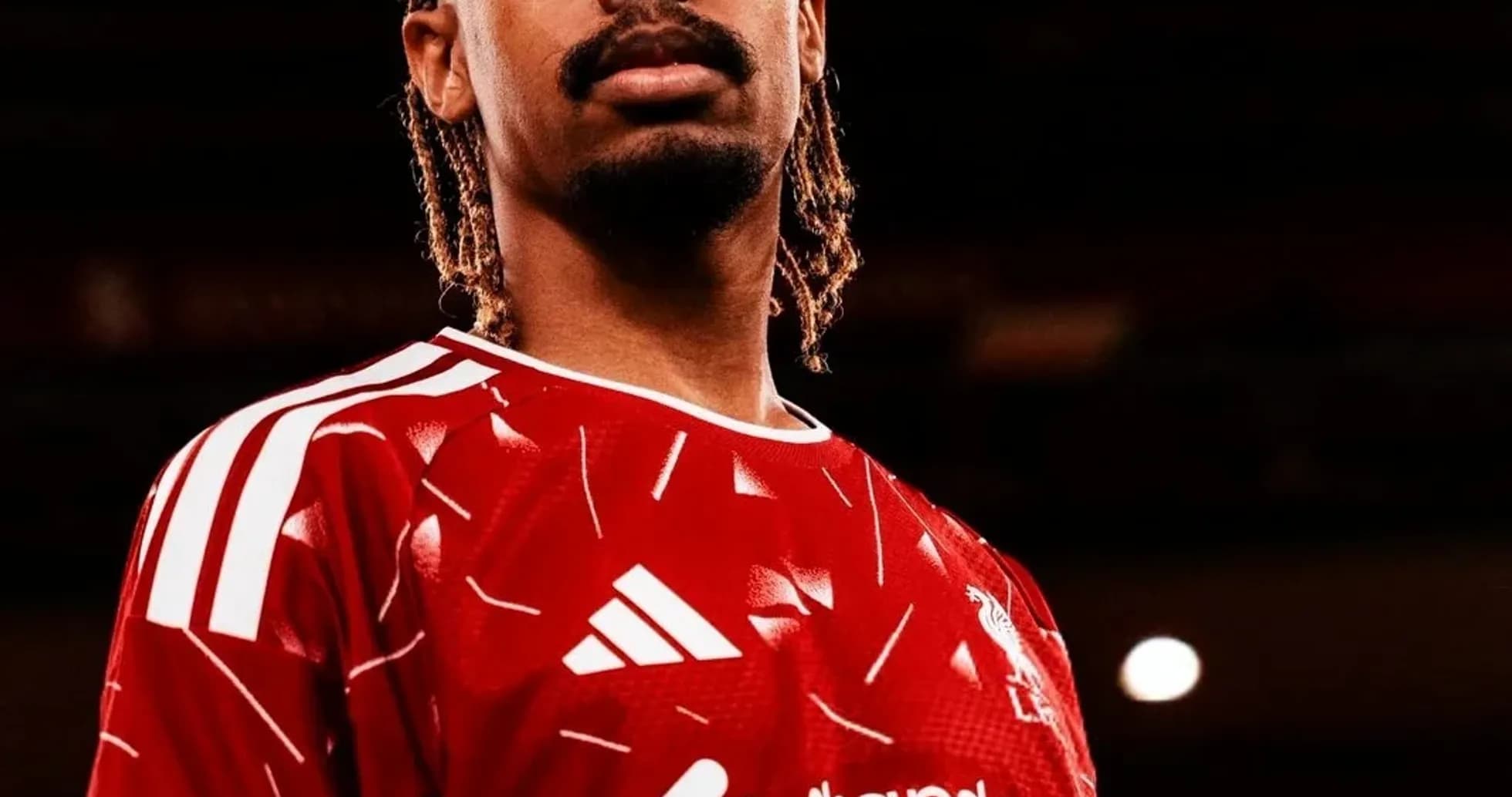 Futbolchi qizil formada old tomondan ko'rinadi