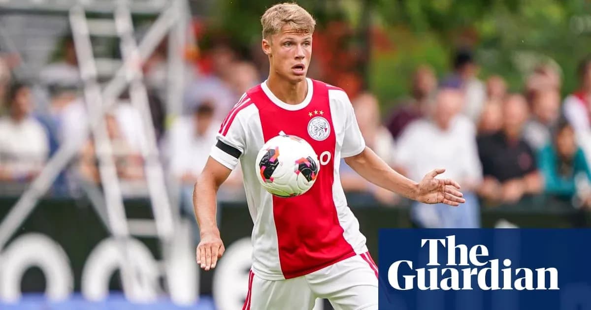 Futbolchi Ajax formasi bilan to'pni ushlab turibdi Futbolchi Ajax formasi bilan to'pni ushlab turibdi