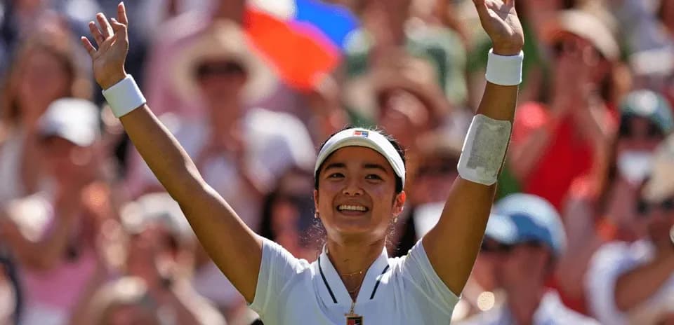 Tennis player celebrating with raised arms in crowd