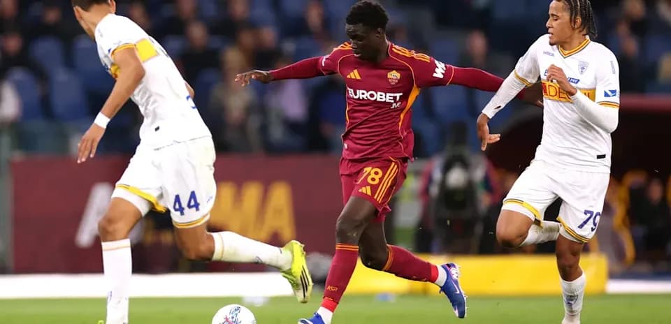 AS Roma player dribbling past two defenders