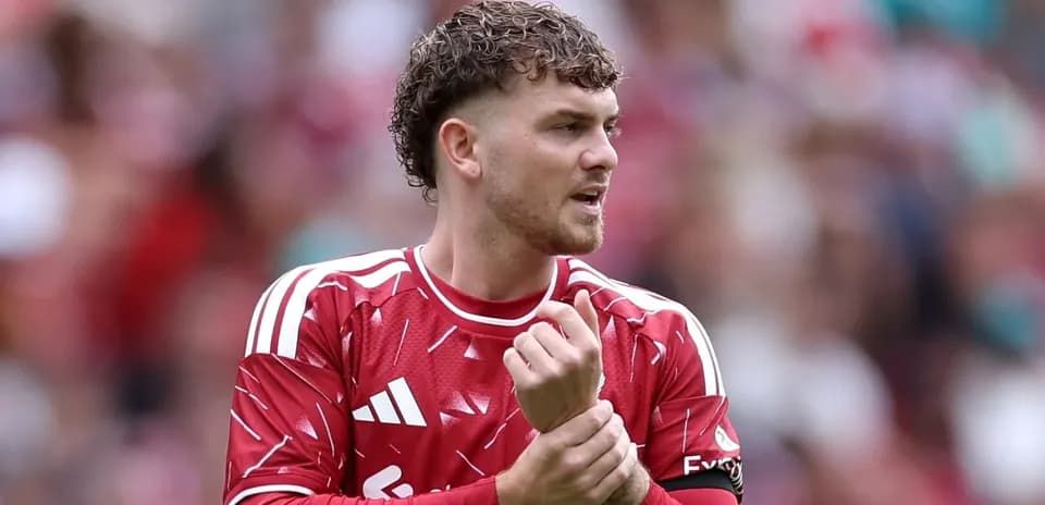 Futbolchi o'yin davomida qo'lini tekshirayotgan
