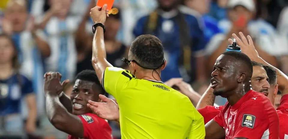 Referee showing red card to player during match