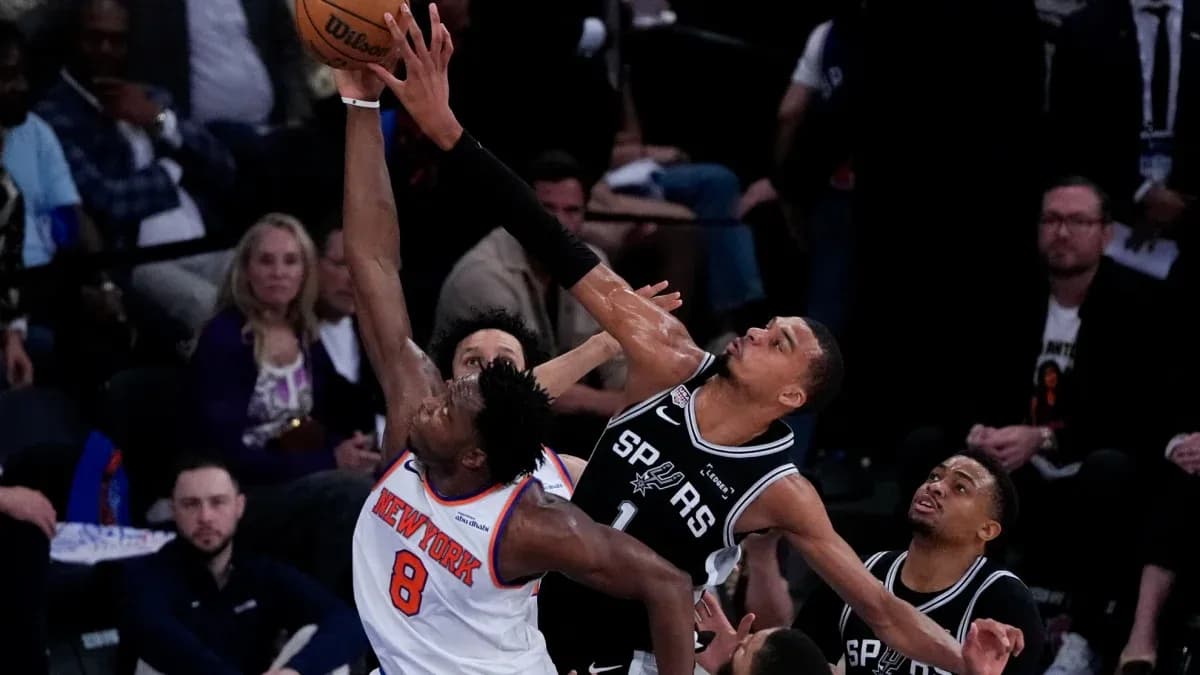 New York player attempting a shot against San Antonio defenders