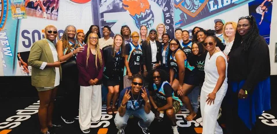 Gruppa odamlar New York Liberty logotipi oldida