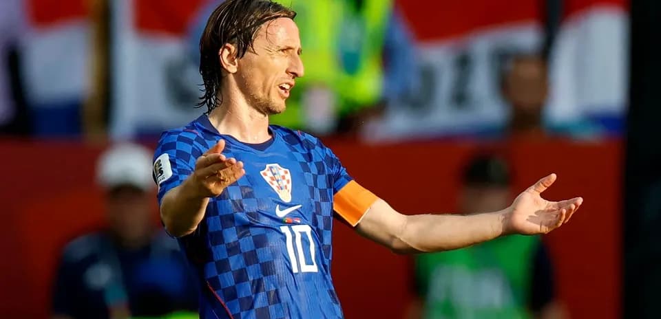 Futbolchi maydonda qo'llarini cho'zayotgan