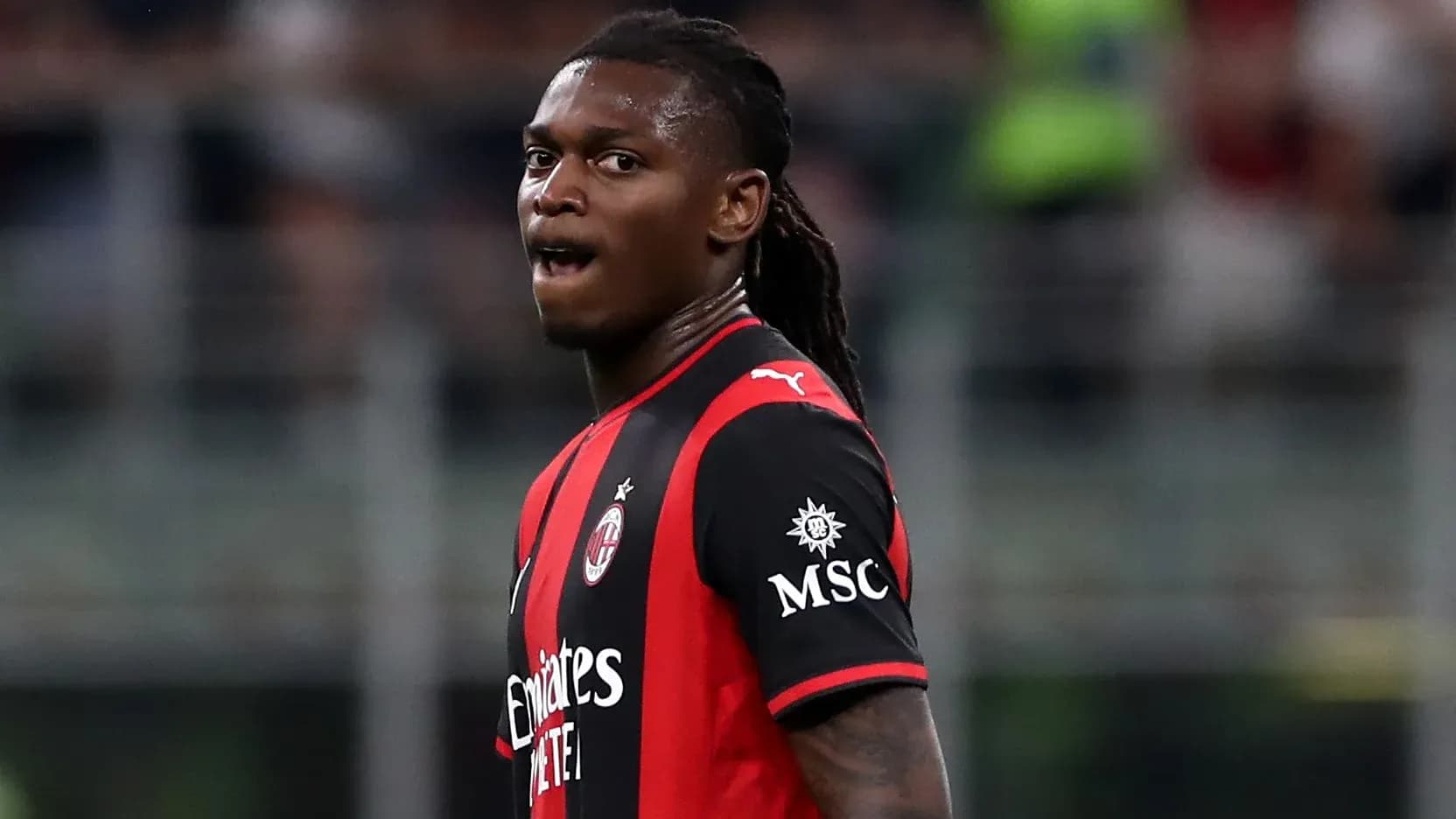 Futbolchi maydonda harakatda, AC Milan formasi kiygan