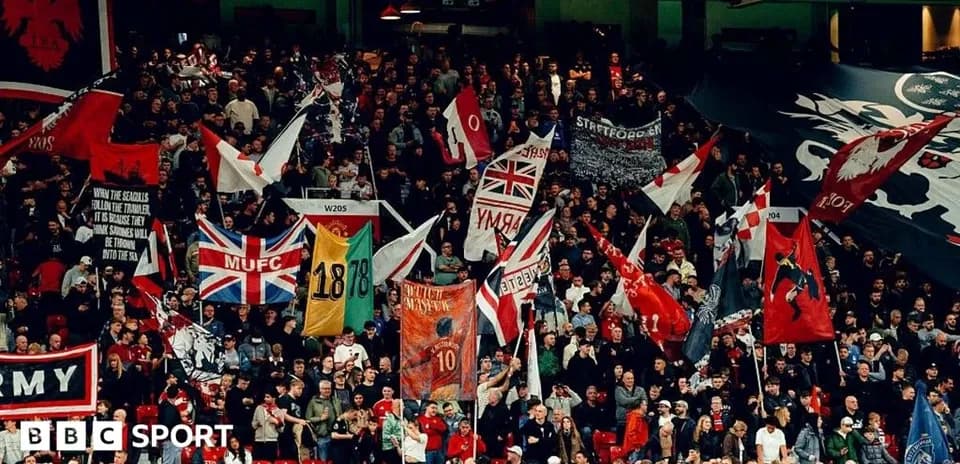 Futbol stadionida muxlislar bayroqlar bilan