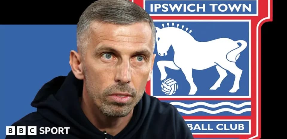 Trenerning Ipswich Town logosi oldida intervyu berishi