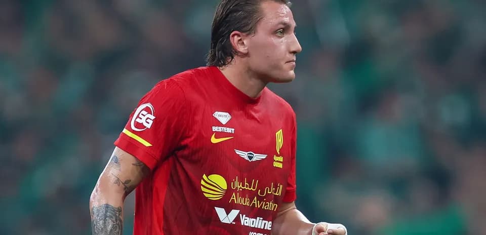 Futbolchi qizil forma kiyib, maydonda harakatda